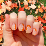 Translucent orange curves on clear nail wrap nail design