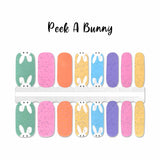 Easter bunny poking it eyes and ears up over specked pastel nail wrap nail design.  