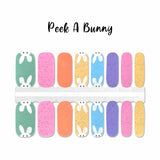 Easter bunny poking it eyes and ears up over specked pastel nail wrap nail design.