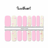 Combination of solid pink nail wraps and gold glitter stripes on white with little pink hearts accents nail wrap nail design.