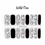 Solid black with multi colored leopard spots with black outlines on white nail wrap nail design.  