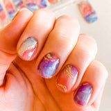 red marble nail design mixed with blue marble nail design and gold glitter mixed throughout nail wrap nail design.