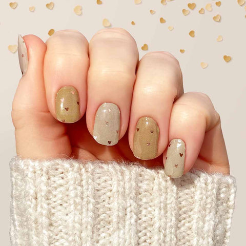 Two different shades of nude with tiny rose gold foil hearts nail wrap nail design. 