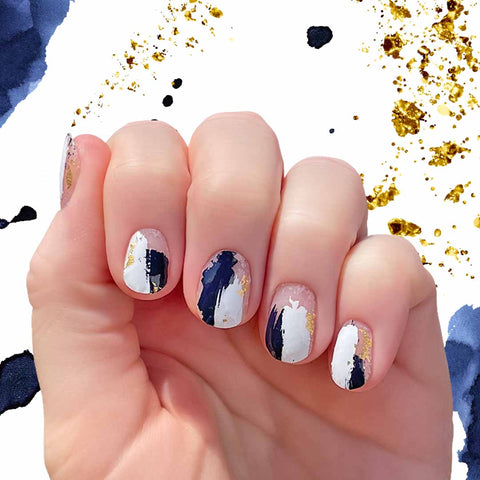 Mix of dark navy blue and white brush strokes dwith some gold foil spots on transparent nail wrap nail designs