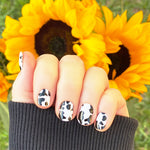 Black cow print on white nail wrap nail design