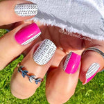 Split color of half bright pink and half white with little black feather hash marks nail wrap nail design