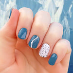 A combination of solid cobalt blue, black spots on white and white curved lines  nail wrap nail design.  