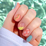 Mix of solid mint, solid peach, and a combination of circles, curves, and daisies nail wrap nail design.  
