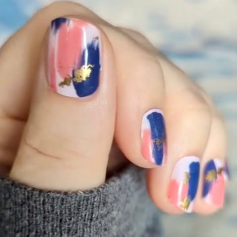 Pink and blue art brushed with gold foil accents on a light pink background nail wrap nail design